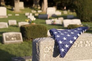 A folded US flag on a grave.